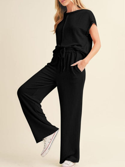 Woman wearing a black jumpsuit on a beige background