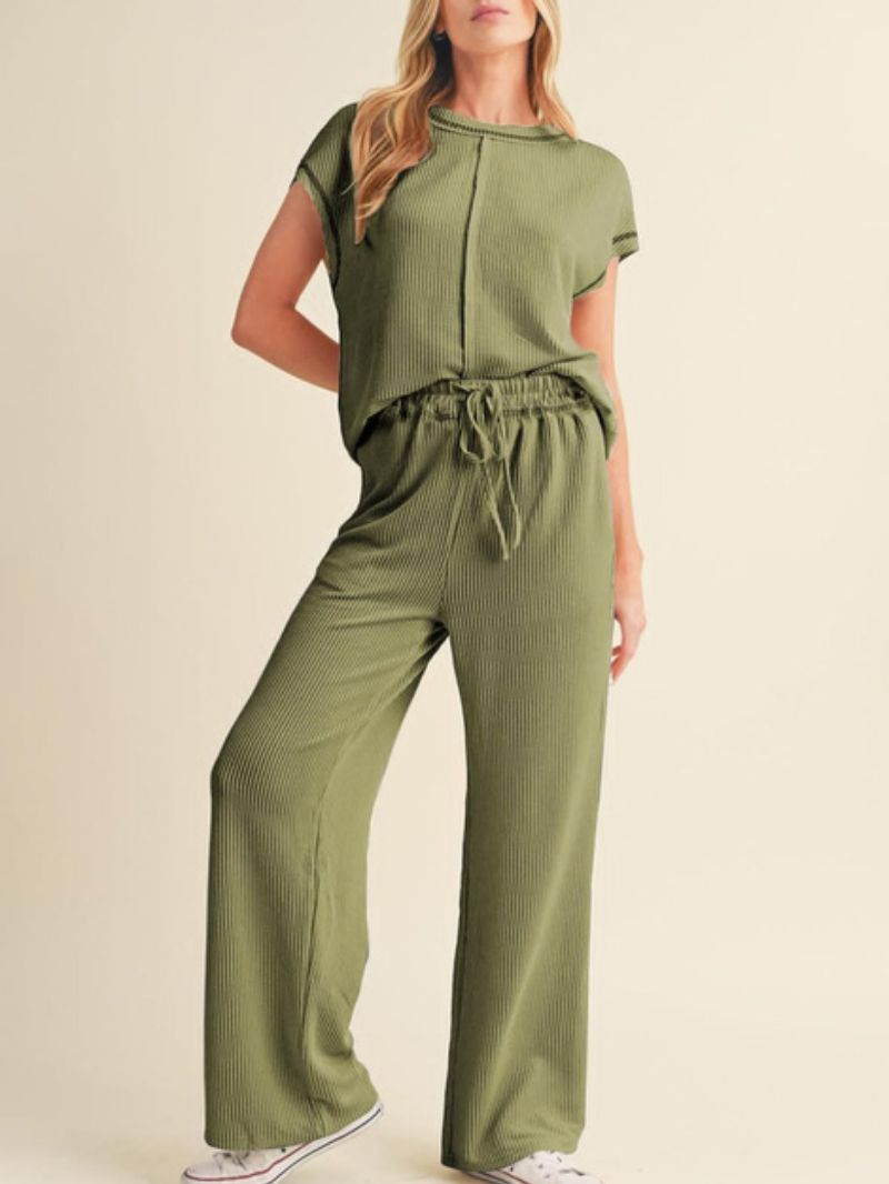 Woman wearing a green jumpsuit on a beige background